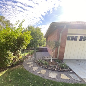 Curved crushed granite walkway with flagstone steppers beside an Edina garage