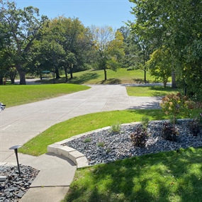 Finished Golden Valley front yard with a curved limestone garden wall, trap rock, and new plantings