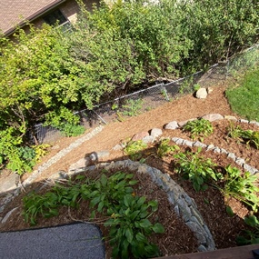 Rebuilt flagstone garden terraces and mulched path in an Edina backyard