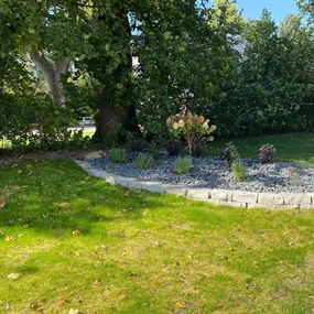 Renovated front yard bed with limestone blocks, trap rock, hydrangeas, and ninebark