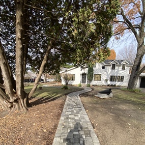 Long Belgard paver walkway connecting the yard to the home’s front entrance