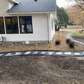 Flagstone stepping-stone path beside a home with crushed granite ground cover
