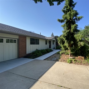 Front driveway and overgrown landscape beds before renovation at an Edina home